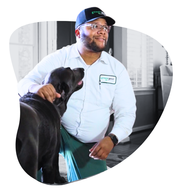 pest technician petting a dog in a house